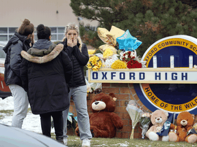 People visit a makeshift memorial outside of Oxford High School on December 1, 2021 in Oxford, Michigan, following a deadly shooting spree.