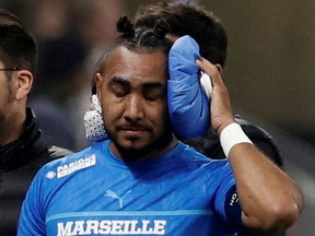 Olympique de Marseille's Dimitri Payet walks off the pitch injured after being hit by a water bottle thrown by a fan leading to the game being interrupted.