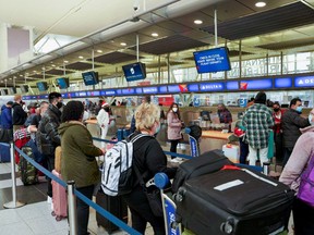 Passengers line up at John F. Kennedy International Airport after airlines announced numerous cancellations during the spread of the Omicron coronavirus variant on Christmas Eve in Queens, New York City.