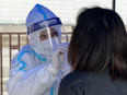 A COVID-19 test swab is administered in Tianjin, China on Jan. 9, 2022. After Omicron was detected in Beijing last week, Chinese health authorities attempted to blame it on Canadian mail.