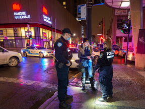 Montreal Police stop and question a woman while enforcing curfew orders on Dec. 31, 2021.