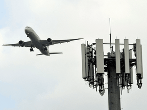 A United Airlines Boeing 787 Dreamliner flies above a cellular tower at Los Angeles International Airport. In the U.S., there’s a “little bit of a tug of war about who calls the shots” between the aviation industry and telecom industry, an expert says.