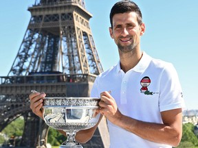 Novak Djokovic poses on June 14, 2021, in front of The Eiffel Tower in Paris, one day after winning the Roland Garros 2021 French Open tennis tournament.