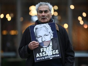 A supporter of WikiLeaks founder Julian Assange holds a placard during a protest against his extradition to the US outside the High Court in London on January 24, 2022