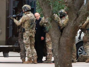 Authorities escort a hostage out of the Congregation Beth Israel synagogue in Colleyville, Texas, on Jan. 15, 2022.