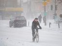 Eine Frau fährt am 17. Januar 2022 während eines Schneefalls in Montreal, Quebec, Fahrrad. Es wird erwartet, dass das kalte Wetter anhält, da die kälteste Luft seit Jahren über Ontario und Quebec fegt.