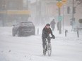 A woman rides a bicycle during a snowfall in Montreal, Quebec on January 17, 2022. Frigid weather is expected to stay, as the coldest air in years sweeps across Ontario and Quebec.