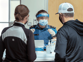 Sailor Second Class Hannah Angel directs residents as they arrive for an asymptomatic COVID-19 testing at the Canada Games Centre in Halifax in April 2021.