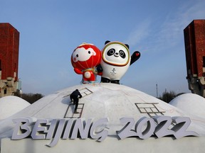 A worker sets up an installation featuring Bing Dwen Dwen, the Beijing 2022 Winter Olympic Mascot and Shuey Rhon Rhon, the 2022 Beijing Winter Paralympic Games Mascot, in Beijing, China January 11, 2022. REUTERS/Tingshu Wang