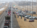 Unterstützer des „Freedom Convoy 2022“ sind am Montag, den 24. Januar 2022, am Rande des Trans-Canada Highway östlich von Calgary versammelt.