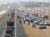 Supporters of the “Freedom Convoy 2022” are pictured gathered on the edge of the Trans-Canada Highway east of Calgary on Monday, January 24, 2022.