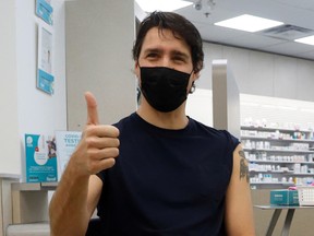 Prime Minister Justin Trudeau reacts after receiving his booster injection of a coronavirus vaccine at a pharmacy in Ottawa, on Jan. 4.