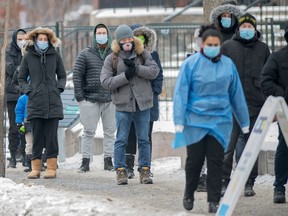 Die Menschen warten am Mittwoch, den 29. Dezember 2021, an einer COVID-19-Test- und Impfstelle in Montreal in einer Schlange, während die COVID-19-Pandemie in Kanada anhält