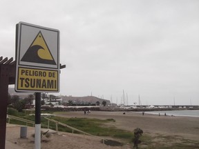 A tsunami warning sign on a beach in Peru.