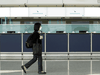 A woman walks past empty counters of Cathay Pacific at Hong Kong International Airport following fresh measures to control COVID-19 infections in Hong Kong, January 11, 2022.