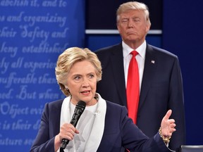 Republican presidential candidate Donald Trump listens on October 9, 2016, to Democratic presidential candidate Hillary Clinton during the second presidential debate at Washington University in St. Louis, Missouri.