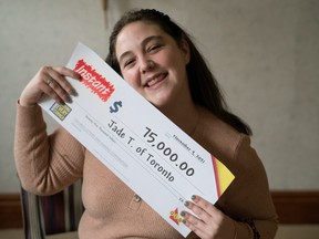 Jade Turner poses with her $75,000 big cheque from OLG after winning the prize on an Instant scratch ticket she bought on Thanksgiving in her office in Markham, Ont.