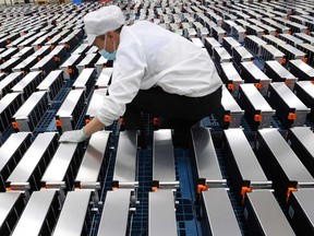 A worker examines lithium car batteries at a factory in Nanjing in China's eastern Jiangsu province, in a file photo from March 12, 2021.