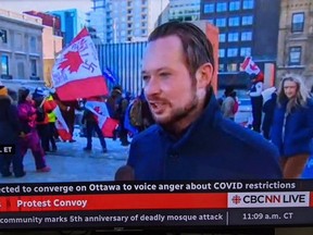 Alberta MP Michael Cooper said he did an impromptu TV interview and moments later he learned via social media that someone who he is not associated with was standing behind his back, holding a flag with an “evil symbol” on it.