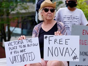 A woman outside the Park Hotel protests the pending explusion of Serbian tennis player Novak Djokovic, in Melbourne, Australia January 6, 2022.