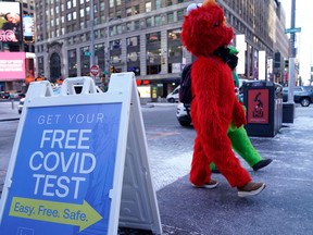 Mascots walks past a testing sign as people line up for Covid-19 testing in Times Square January 4, 2022, in New York City.