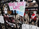 Protest signs are attached to the main gate of Parliament Hill, as demonstrations by truckers and their supporters against coronavirus disease (COVID-19) vaccination mandates continue, in Ottawa, Ontario, Canada , January 31, 2022. REUTERS/Blair Gable