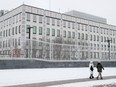 People walk near the U.S. embassy in Kyiv, Ukraine January 24, 2022. The United States said in a statement it was ordering the departure of eligible family members of staff from its embassy in Ukraine and said all citizens should consider leaving due to the threat of military action from Russia. REUTERS/Gleb Garanich
