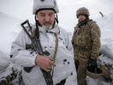 Ukrainian soldiers stand in a trench on the front line in the Luhansk area, eastern Ukraine, Jan. 27, 2022.