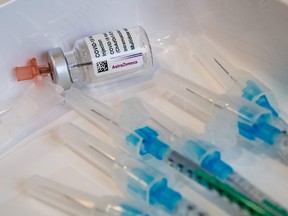 An empty vial of the AstraZeneca COVID-19 vaccine and some syringes are seen on a tray at the university hospital in Halle/Saale, eastern Germany.