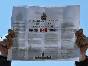 A protester holds a copy of Canadian Charter of Rights and Freedoms at a rally against COVID-19 vaccines, masks and other pandemic measures, in Edmonton on September 4, 2021.