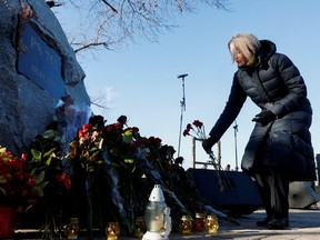 Eine Frau platziert Blumen während einer Zeremonie zum zweiten Jahrestag des Absturzes des Fluges PS752 der Ukraine International Airlines im iranischen Luftraum in Kiew, Ukraine am 8. Januar 2022.