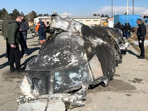 People analyze the fragments and remains of the Ukraine International Airlines plane that was shot down by Iran on Jan. 8, 2020.