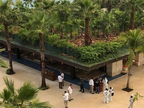 Members of the National Guard keep watch as forensic technicians and hotel employees stand near a scene where three Canadian citizens were injured by gunshots at Hotel Xcaret, in Playa del Carmen, Mexico.