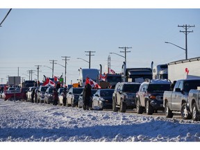 Camionneurs protestant contre un mandat de vaccination contre la COVID-19 pour ceux qui traversent la frontière canado-américaine sur la route transcanadienne à l'ouest de Winnipeg, au Manitoba.