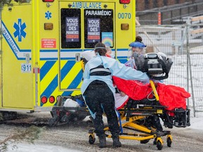 Paramedics transfer a person from an ambulance into a hospital in Montreal, Sunday, Jan. 9, 2022. The Health Department says data from the last 24 hours indicates a 140-jump in hospitalization from the previous day, for a total of 2,436. The province is also reporting 11,007 new cases of COVID-19.