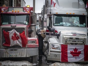 A woman greets a truck driver on the vehicle- lined streets in Centretown on Sunday, February 6, 2022, during the Freedom Convoy protest.