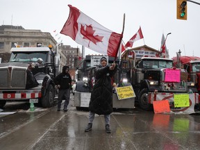 A supporter of the Freedom Convoy demonstration waves a Canadian flag in front of Parliament Hill, downtown Ottawa on February 08, 2022.
Photo by Jean Levac/Postmedia