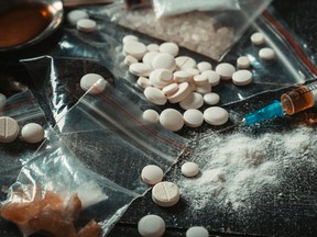 Hard drugs on dark table. Drug syringe and cooked heroin