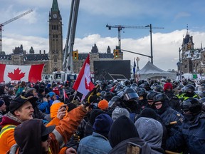 Police face off with demonstrators participating in a protest organized by truck drivers opposing vaccine mandates on Wellington St. on February 19, 2022 in Ottawa, Ontario.