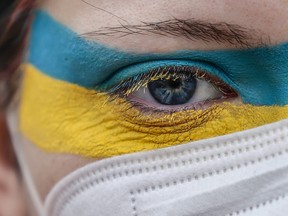 A woman in Germany wears makeup in the colours of the Ukrainian flag, protesting against the Russian invasion of Ukraine, on Feb. 24, 2022.