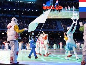 A games volunteer acts as a flag bearer of  Team Virgin Island, US  during the Opening Ceremony of the Beijing 2022 Winter Olympics at the Beijing National Stadium on February 04, 2022 in Beijing, China.