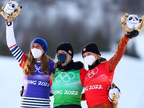 ZHANGJIAKOU, CHINA - FEBRUARY 09: Gold medalist Lindsey Jacobellis of Team USA (C), silver medalist Chloe Trespeuch of Team France (L) and bronze medalist Meryeta Odine of Team Canada (R) celebrate during the Women's Snowboard Cross Flower Ceremony on Day 5 of the Beijing 2022 Winter Olympics at Genting Snow Park on February 09, 2022 in Zhangjiakou, China.