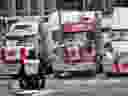 A police officer stands guard near trucks participating in a blockade of downtown streets near the parliament building as a demonstration led by truck drivers protesting vaccine mandates continues on February 16, 2022 in Ottawa, Ontario.