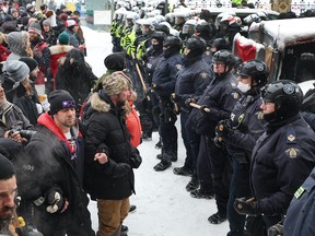 Police face off with demonstrators participating in a protest against anti-COVID measures, on February 19, 2022 in Ottawa.