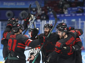 Maxim Noreau of Canada celebrates scoring their fourth goal with teammates.