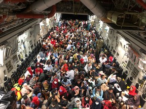 Evakuierte, die als kanadische berechtigte Personen bezeichnet werden – viele Dolmetscher wurden zurückgelassen – sitzen in einem C-177 Globemaster III-Transportflugzeug der kanadischen Luftwaffe für ihren Flug von Kabul nach Kanada am 23. August 2021.