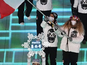 Mexico's flag bearer Donovan Carrillo, left, and Sarah Schleper lead the delegation during the opening ceremony of the Beijing 2022 Winter Olympic Games.