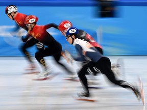 (L to R) China's Ren Ziwei, Latvia's Roberts Kruzbergs, Turkey's Furkan Akar and South Korea's Hwang Dae-heon compete in a semi-final heat of the men's 1000m short track speed skating event during the Beijing 2022 Winter Olympic Games at the Capital Indoor Stadium in Beijing on February 7, 2022.