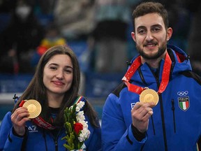 Gold medallists Italy's Amos Mosaner (R) and Italy's Stefania Constantini show their medals  following a ceremony after the mixed doubles tournament of the Beijing 2022 Winter Olympic Games curling competition at the National Aquatics Centre in Beijing on February 8, 2022.