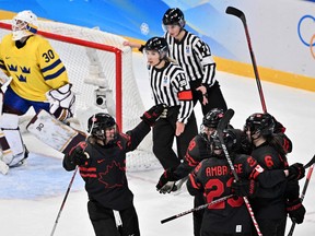 Players of Canada celebrate after teammate Sarah Fillier (out of frame) scored the team's second goal against Sweden during their women's play-offs quarterfinals match of the Beijing 2022 Winter Olympic Games ice hockey competition, at the Wukesong Sports Centre in Beijing on February 11, 2022.